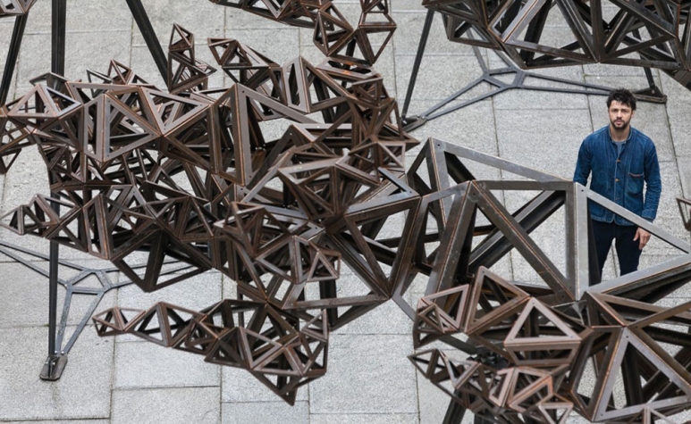 Conrad-Shawcross-RA-stands-in-front-of-The-Dappled-Light-of-the-Sun,-2015-©-Royal-Academy-of-Arts,-Benedict-Johnson-1.jpg